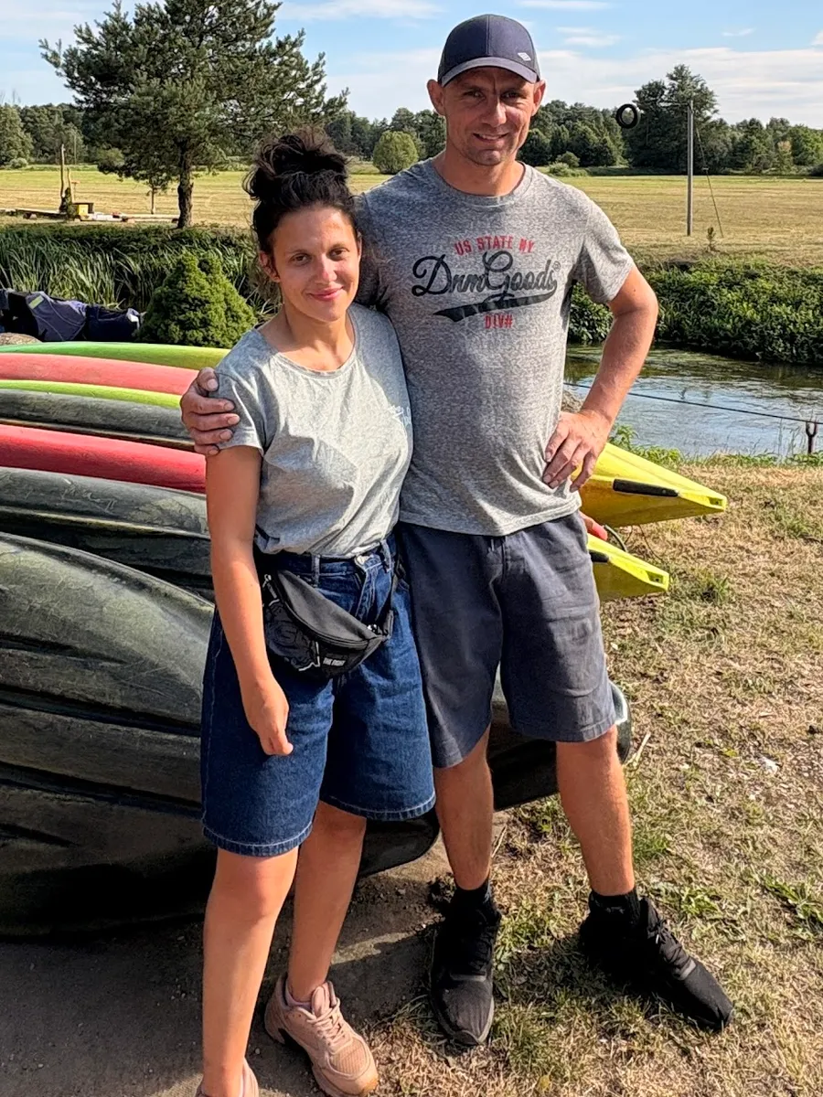 Pyjter Thiel z partnerką nad rzeką, w tle kajaki Młyna Thiel
